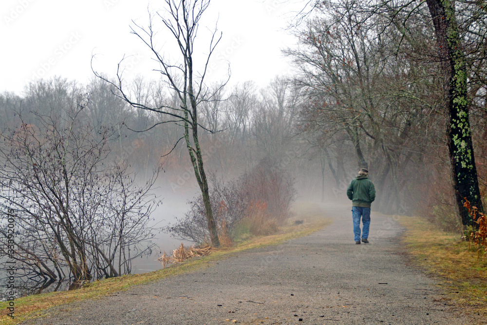 Fototapeta premium Aging Man Walking a Hazy Path Into the Unknown