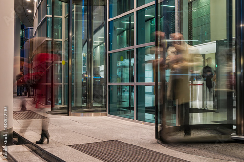  The flow of people passing through the rotating door of the modern office building ,
