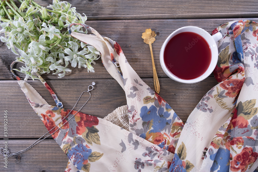 Fototapeta premium on the table is a cup of coffee, next to a women's dress