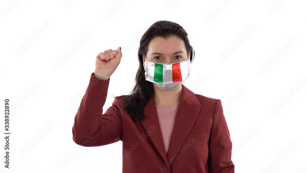 Virus and disease prevention concept. Woman wears a protective medical mask with the image of the flag of Italy. Shows the solidarity with the closed fist hand gesture. Demonstrate solidarity sign. Virus and disease prevention concept. Woman wears a protective medical mask with the image of the flag of Italy. Shows the solidarity with the closed fist hand gesture. Demonstrate solidarity sign.
