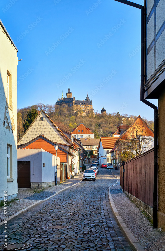 Old town of Wernigerode with a view of the castle through a narrow alley.