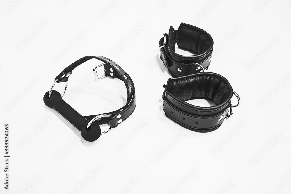 Obraz premium Leather gag and cuffs isolated on a white background