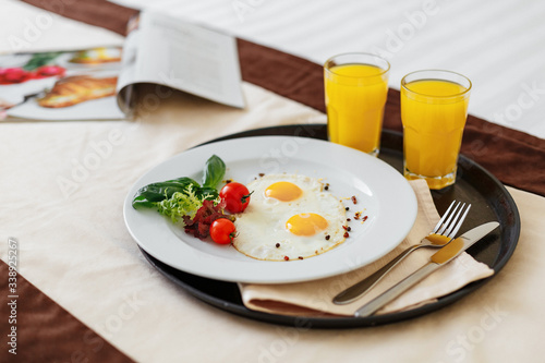 breakfast on the bed, scrambled eggs with vegetables and two glasses of orange juice in the early morning cheers up. Healthy food, veggie food. Cook at home. Breakfast in the hotel.