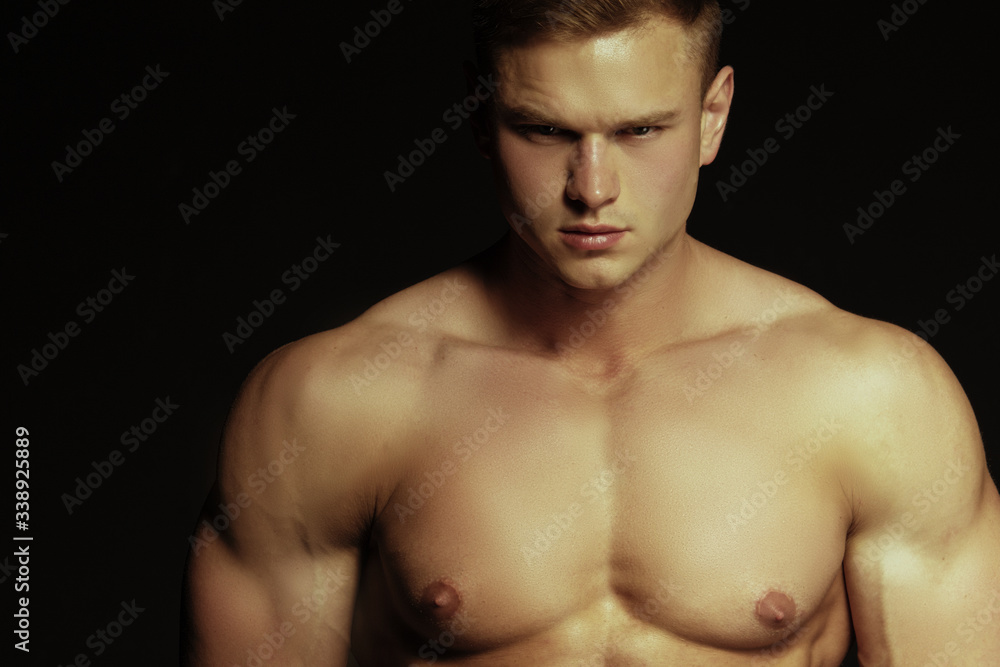 Handsome sport sexy stripped guy portrait on isolated black background Handsome sport sexy stripped guy portrait on isolated black background