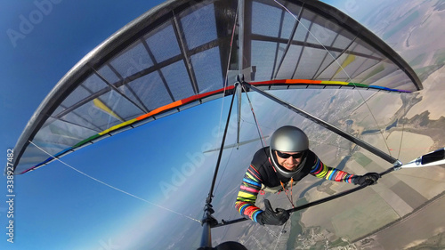 Smiling hang glider pilot shows thumb up