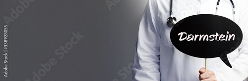Darmstein. Arzt im Kittel hält Sprechblase hoch. Das Wort Darmstein steht im Schild. Symbol für Krankheit, Gesundheit, Medizin photo