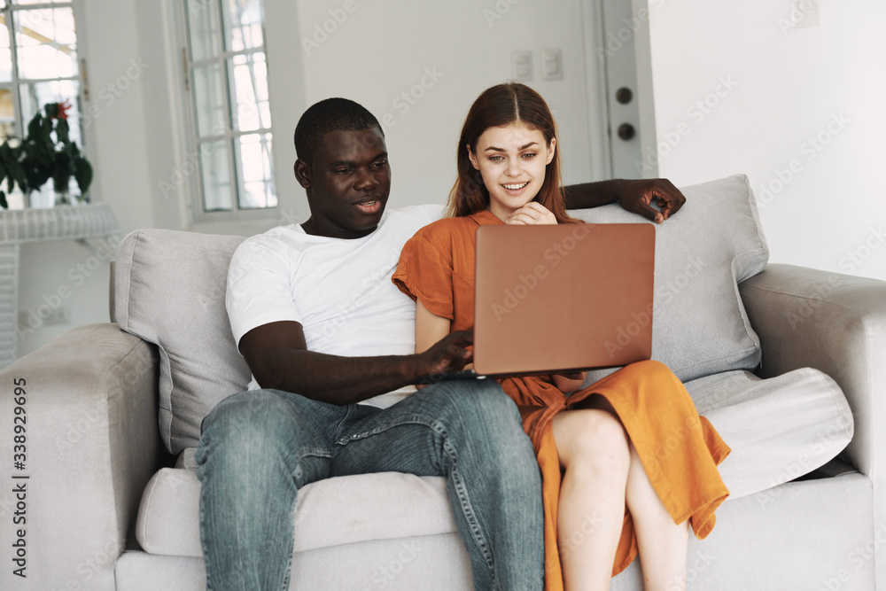 Man and woman at home in front of a laptop watching movies relaxing Man and woman at home in front of a laptop watching movies relaxing