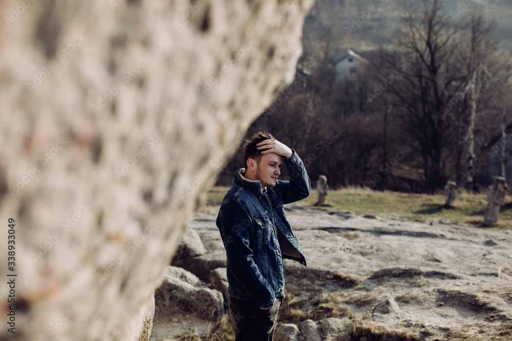 Fototapeta premium Portrait of a young man in the mountains alone