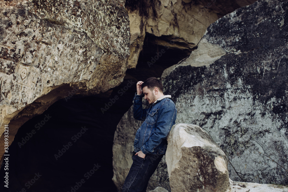 Fototapeta premium Sad young man alone in the mountains
