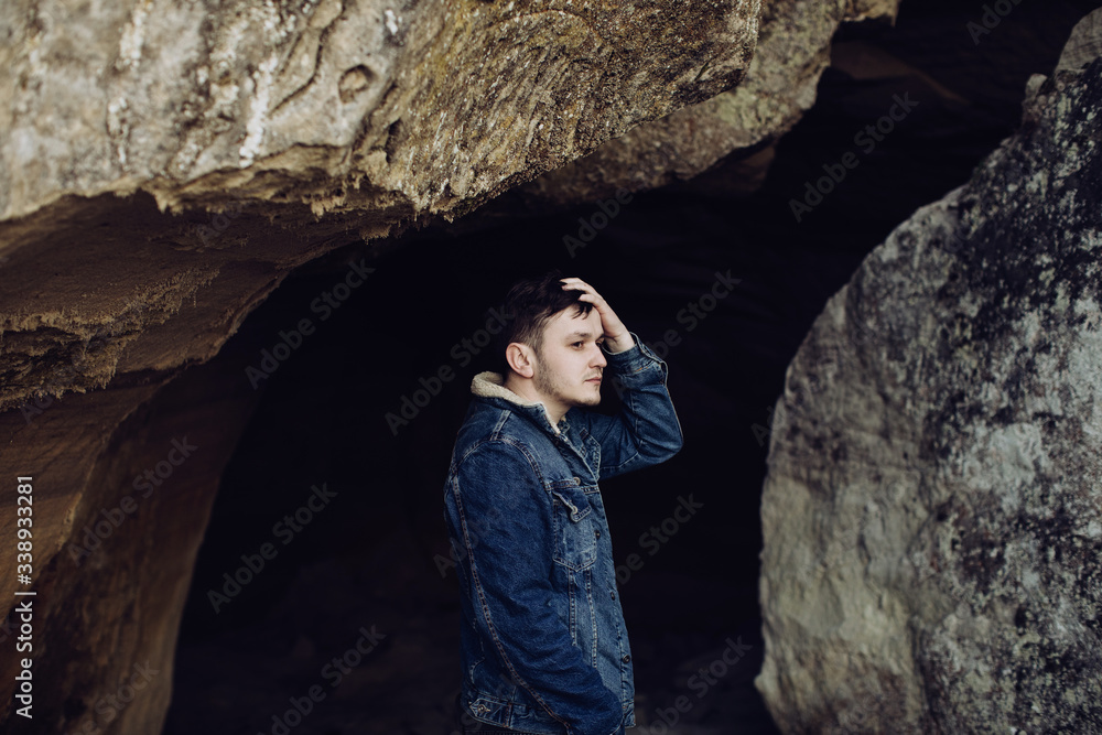 Young man in the mountains in a cave Young man in the mountains in a cave