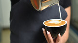 Barista guy makes coffee and pours it into a mug. Small business and addiction concept