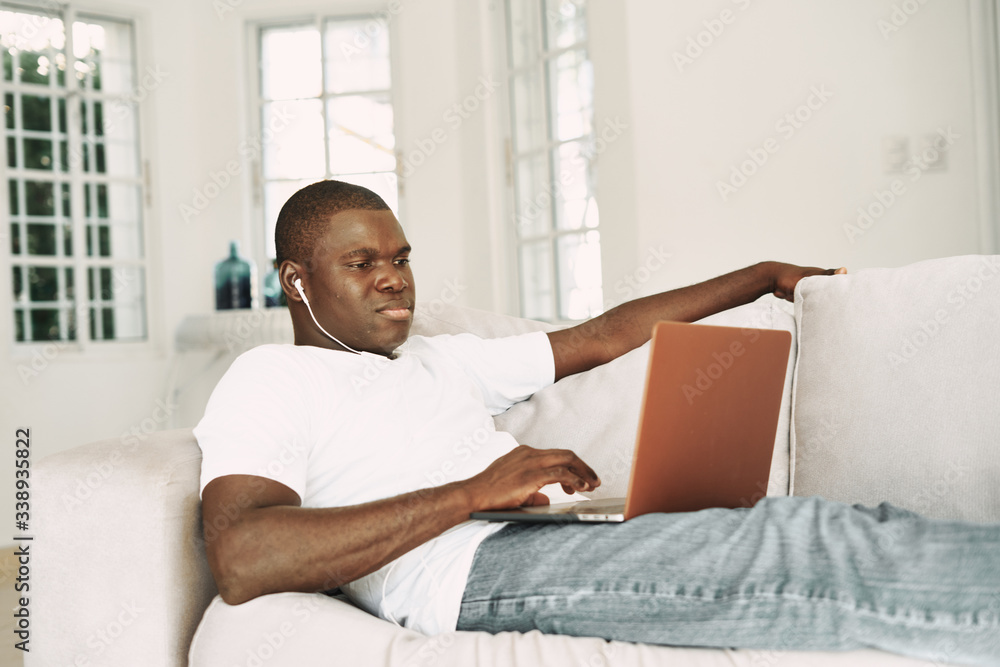 A man of African appearance at home or a laptop in headphones resting A man of African appearance at home or a laptop in headphones resting