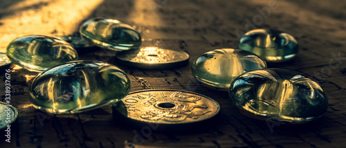 Closeup of a pile of Norwegian money on a cork background, illuminated by a beam of sunlight.