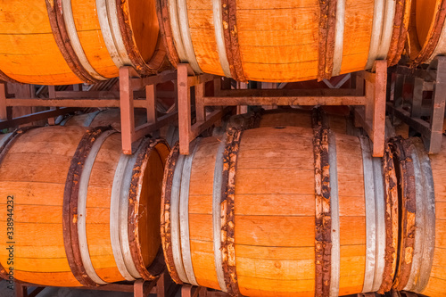 Old wine barrels are stacked outside.