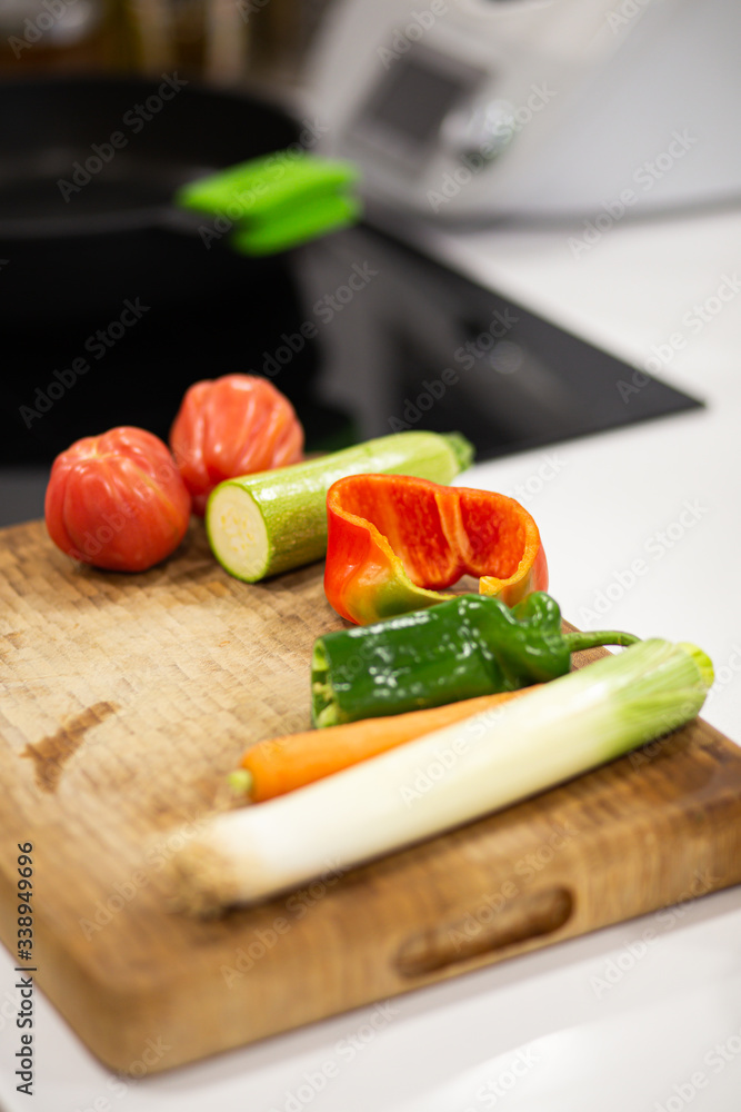 Different vegetables on a wooden cutting board ready to be cooked on a domestic kitchen Different vegetables on a wooden cutting board ready to be cooked on a domestic kitchen
