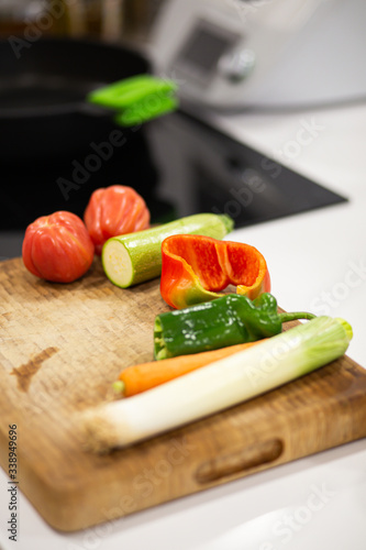 Different vegetables on a wooden cutting board ready to be cooked on a domestic kitchen