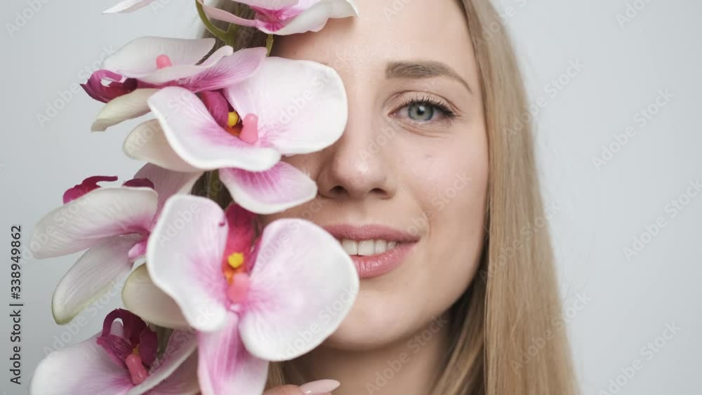 Beautiful girl with flower posing in front of camera Beautiful girl with flower posing in front of camera