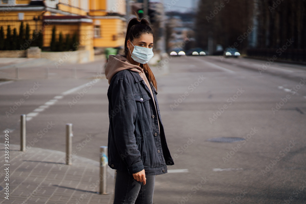 Close up of young woman with surgical mask on face.
