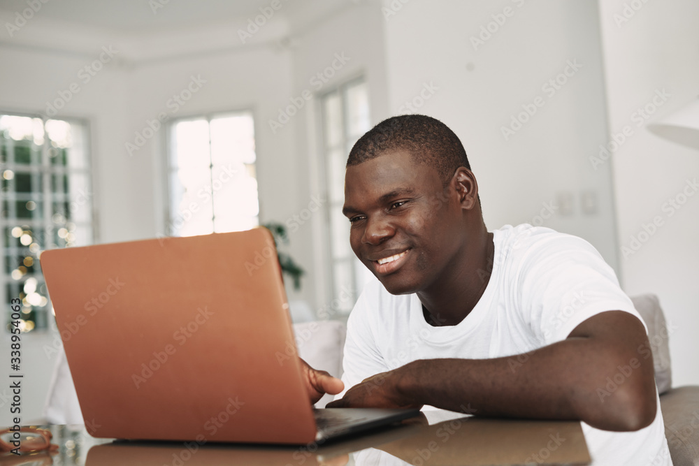 A very African-looking home in front of a laptop communicating tired work A very African-looking home in front of a laptop communicating tired work