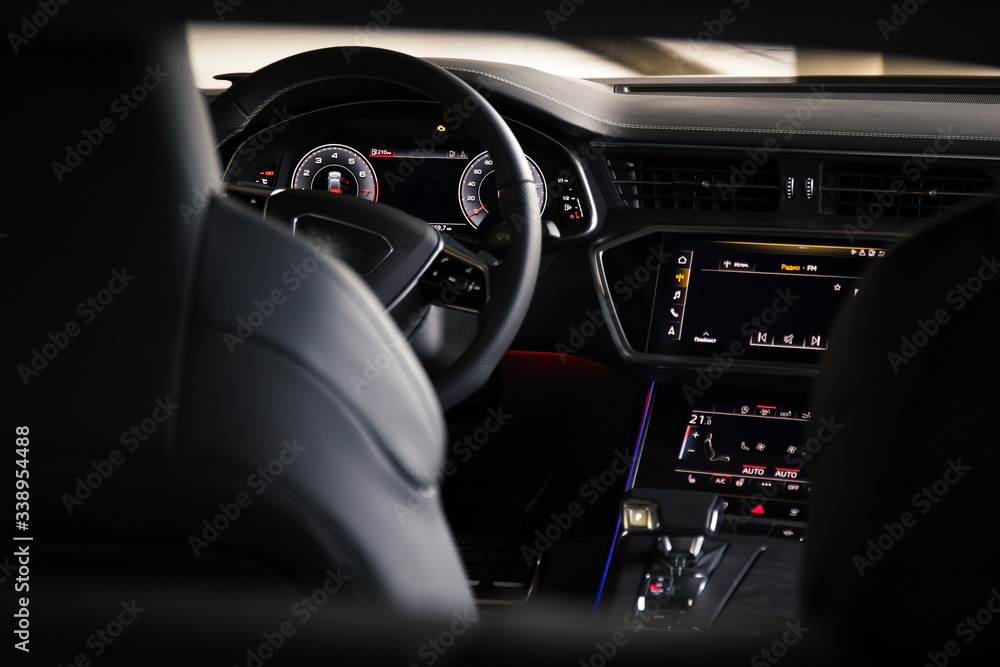 Interior of an ultra modern new luxury car. Leather chairs and wood trim, touch panels with vibration feedback and climate control. Multifunction, automatic transmission