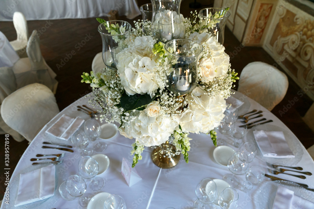Fototapeta premium decoration of wedding table. White ranunculus (persian buttercup) in vase