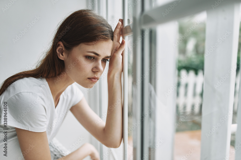 Sad woman looking out the window pensive looking depressed Sad woman looking out the window pensive looking depressed