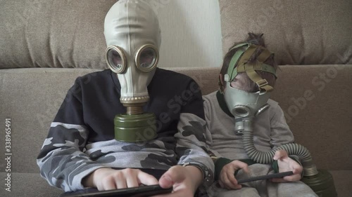Children in gas masks from viruses play with smartphones
