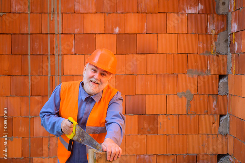 Wallpaper Mural Wood work and diy concept. Construction worker cutting board with handsaw. Carpenter sawing wood. Builder is sawing wooden board with hand saw. Concept of construction. Carpentry workshop concept. Torontodigital.ca