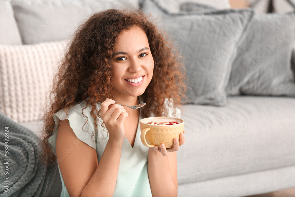 Young woman eating tasty yogurt at home Young woman eating tasty yogurt at home