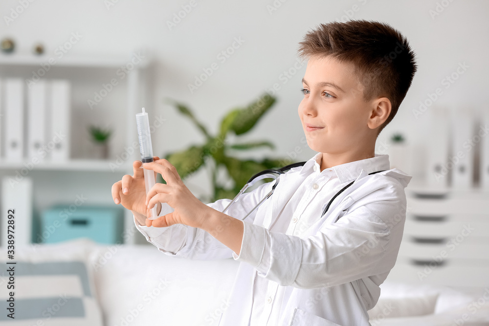 Cute little doctor with syringe in clinic Cute little doctor with syringe in clinic