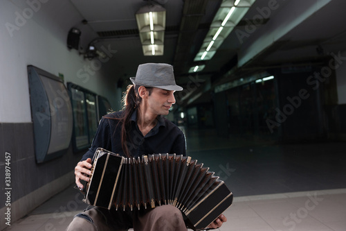 Картината върху платно Tango performer playing a bandoneon with hat in the subway of Buenos Aires