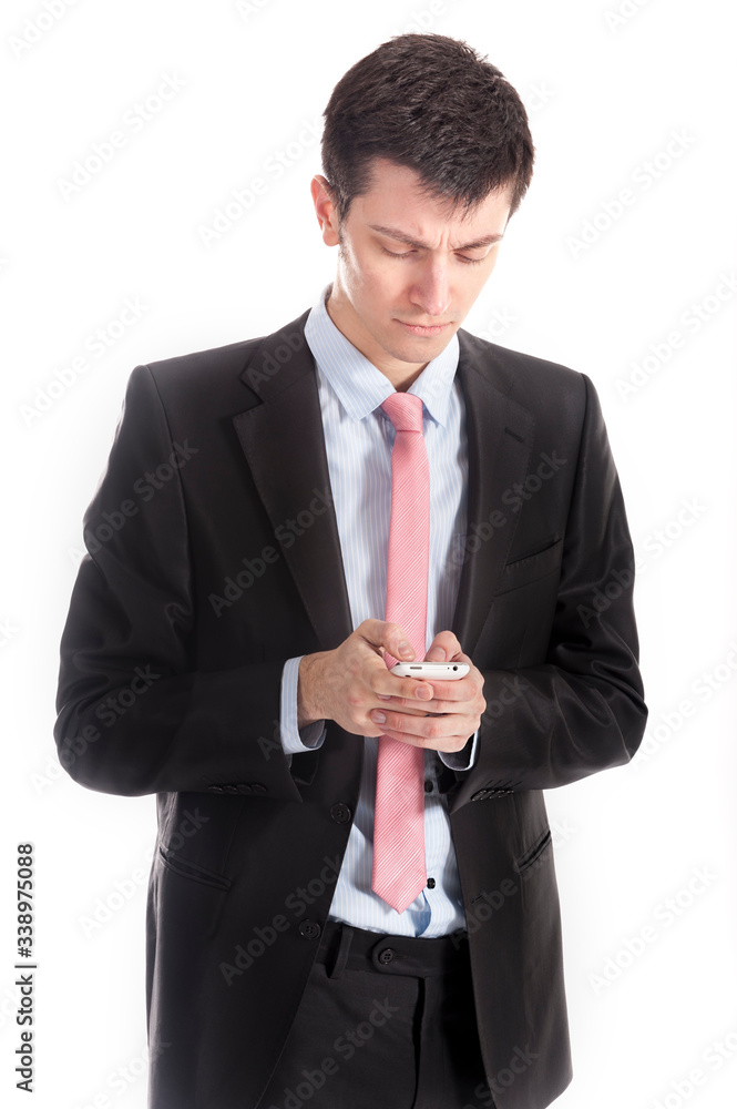 Smart young businessman typing message on his cell phone. He is wearing a suit and concentrating on what is on the screen Smart young businessman typing message on his cell phone. He is wearing a suit and concentrating on what is on the screen