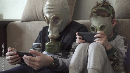Children in gas masks from viruses play with smartphones