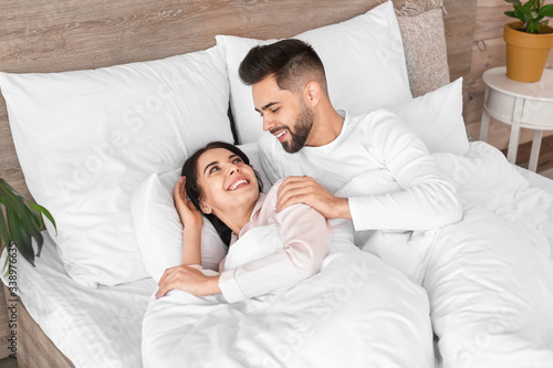 Happy young couple lying in...
