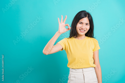 Portrait Asian beautiful young woman made finger OK symbol sign