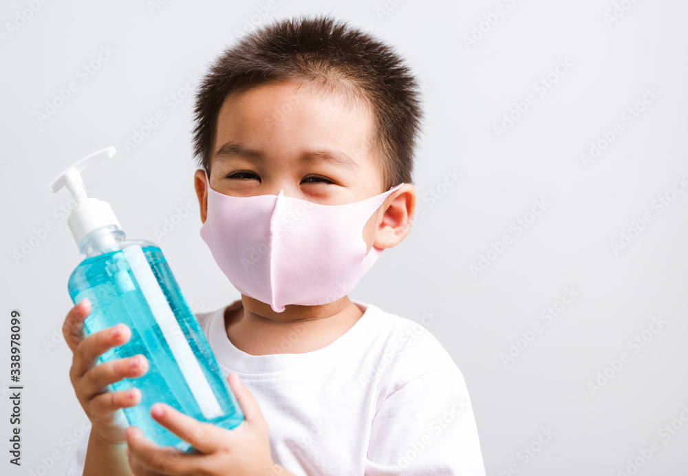 little child boy holding show bottle pump dispenser sanitizer alcohol gel