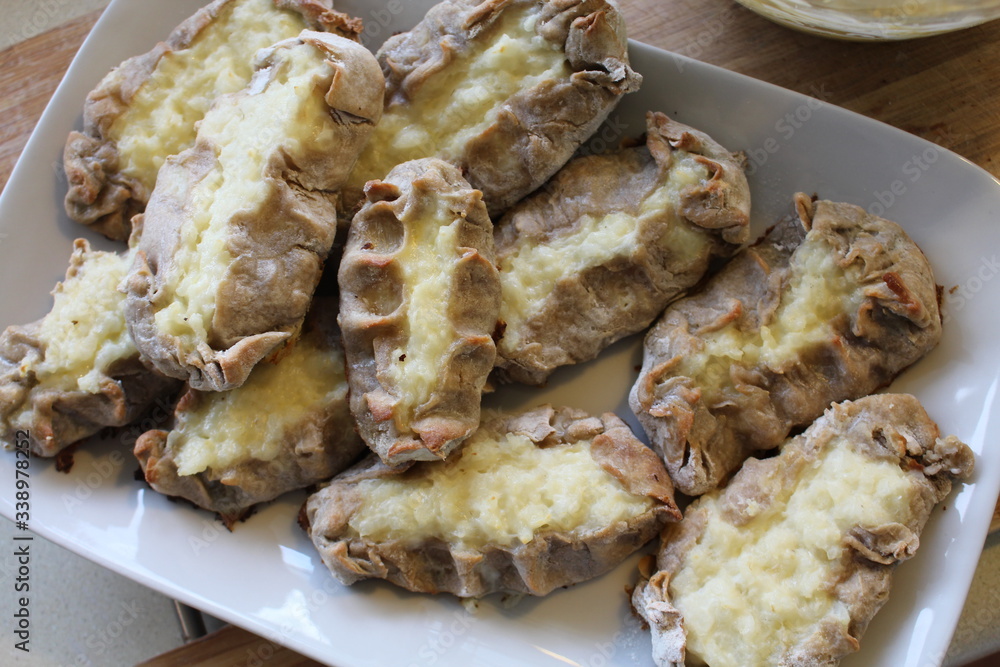Cooked Karelian pies - Pirakka on a baking sheet. Dish of national cuisine - piirakka. Close-up. Cooked Karelian pies - Pirakka on a baking sheet. Dish of national cuisine - piirakka. Close-up.