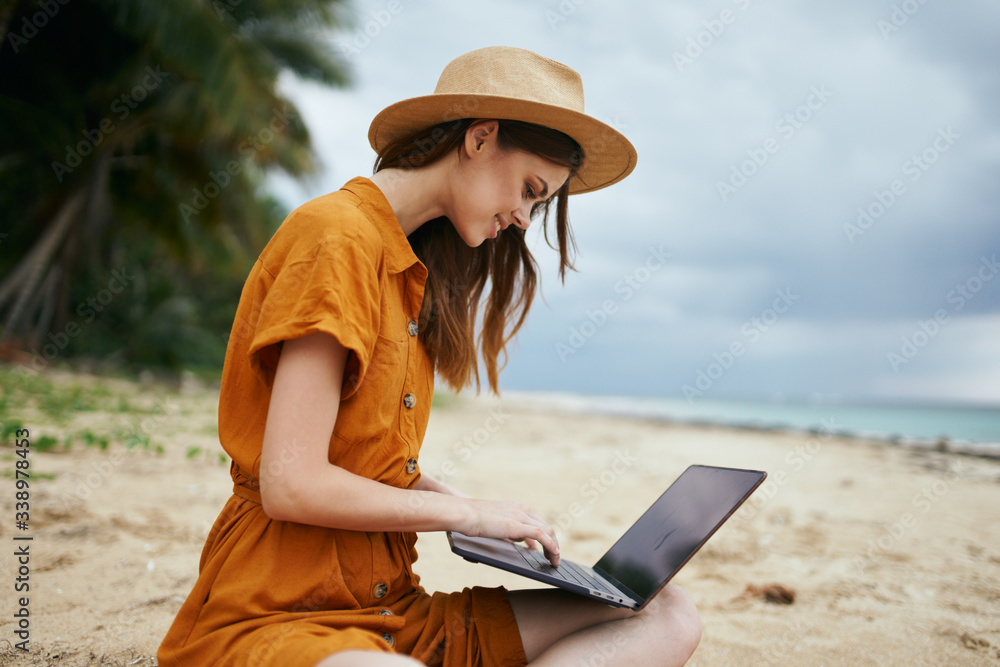 Cheerful woman tourist on the beach in front of laptops chatting vacation