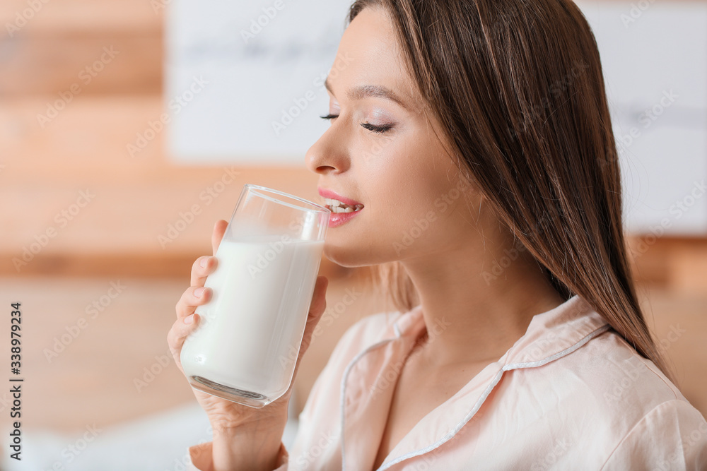 Young woman drinking milk in bedroom Young woman drinking milk in bedroom