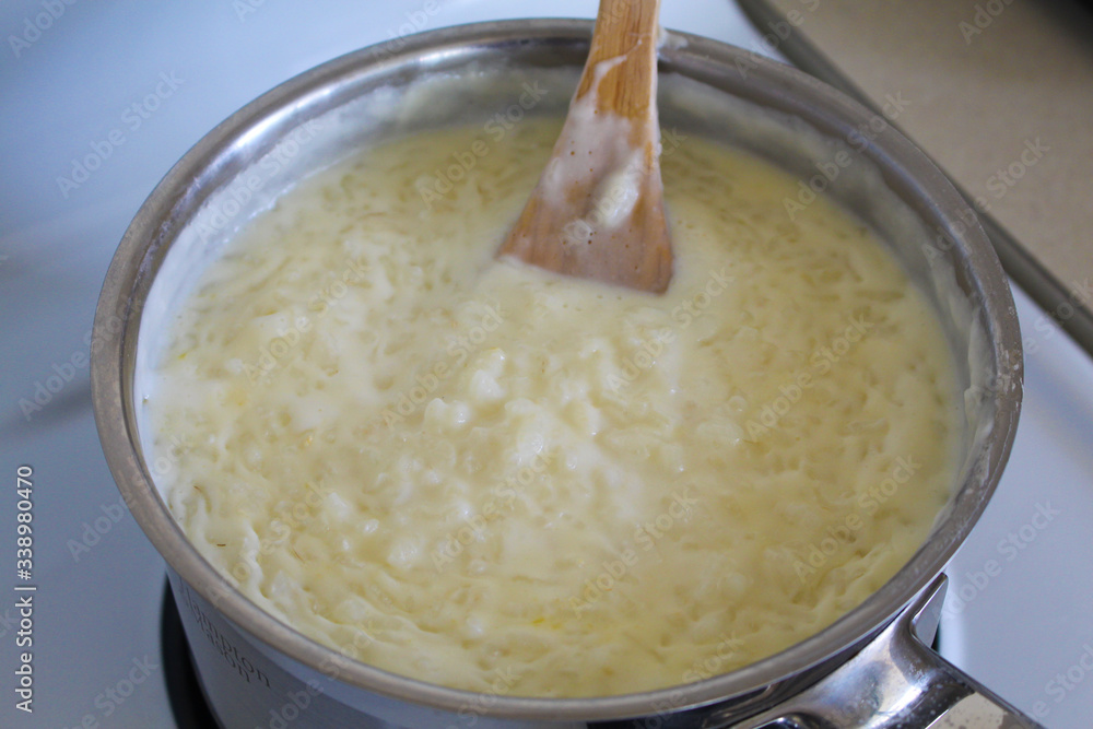 Cooking of rice porridge on oven, the first stage of preparation of national Finnish dish from rye flour and rice - Karelian pies Cooking of rice porridge on oven, the first stage of preparation of national Finnish dish from rye flour and rice - Karelian pies
