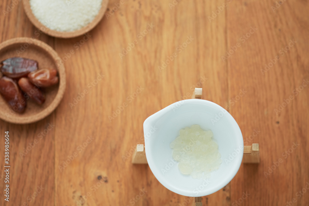 A flatlay overhead shot of the ingredients of water kefir or tibicos drink, including dried dates and organic raw cane sugar. A flatlay overhead shot of the ingredients of water kefir or tibicos drink, including dried dates and organic raw cane sugar.
