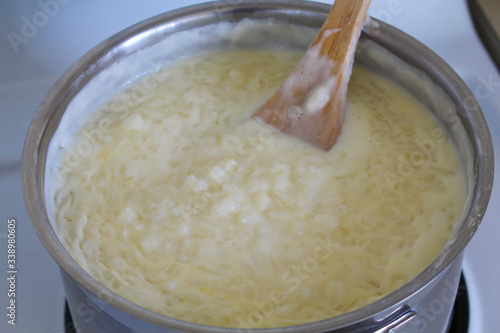 Cooking of rice porridge on oven, the first stage of preparation of national Finnish dish from rye flour and rice - Karelian pies photo