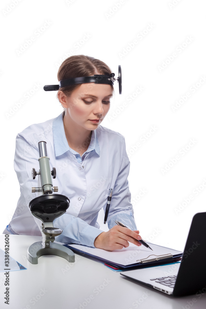 Healthcare and Medicine Concepts. Professional Laboratory Female Researcher in Smock Working With Microscope While Conducting a Research and Making Notes. Healthcare and Medicine Concepts. Professional Laboratory Female Researcher in Smock Working With Microscope While Conducting a Research and Making Notes.