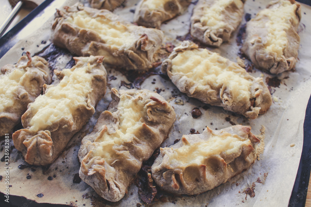 Cooked Karelian pies - Pirakka on a baking sheet. Dish of national cuisine - piirakka. Close-up. Cooked Karelian pies - Pirakka on a baking sheet. Dish of national cuisine - piirakka. Close-up.
