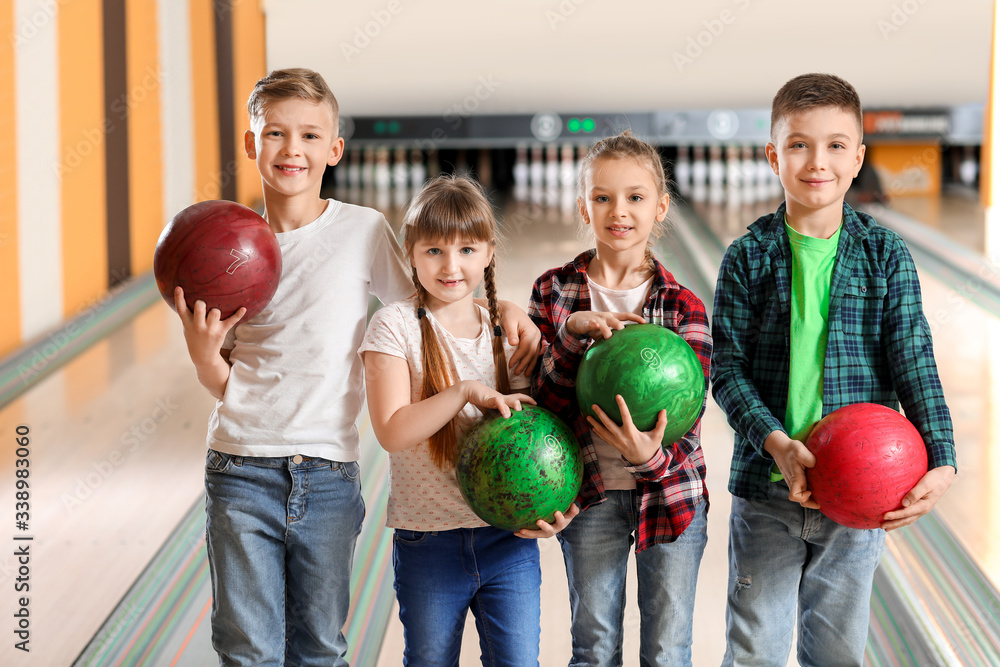 Fototapeta premium Little children playing bowling in club