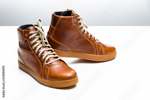 Pair of New Leather Tan Motorcyclist Boots Against White Background.