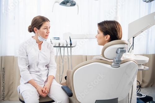 A young woman talking to her dentist in the dental clinic