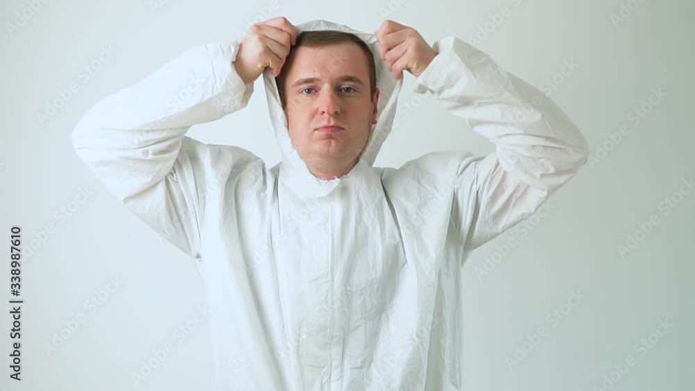 Doctor puts on a protective suit. Disinfector in protective coverall and mask working in office building Doctor puts on a protective suit. Disinfector in protective coverall and mask working in office building