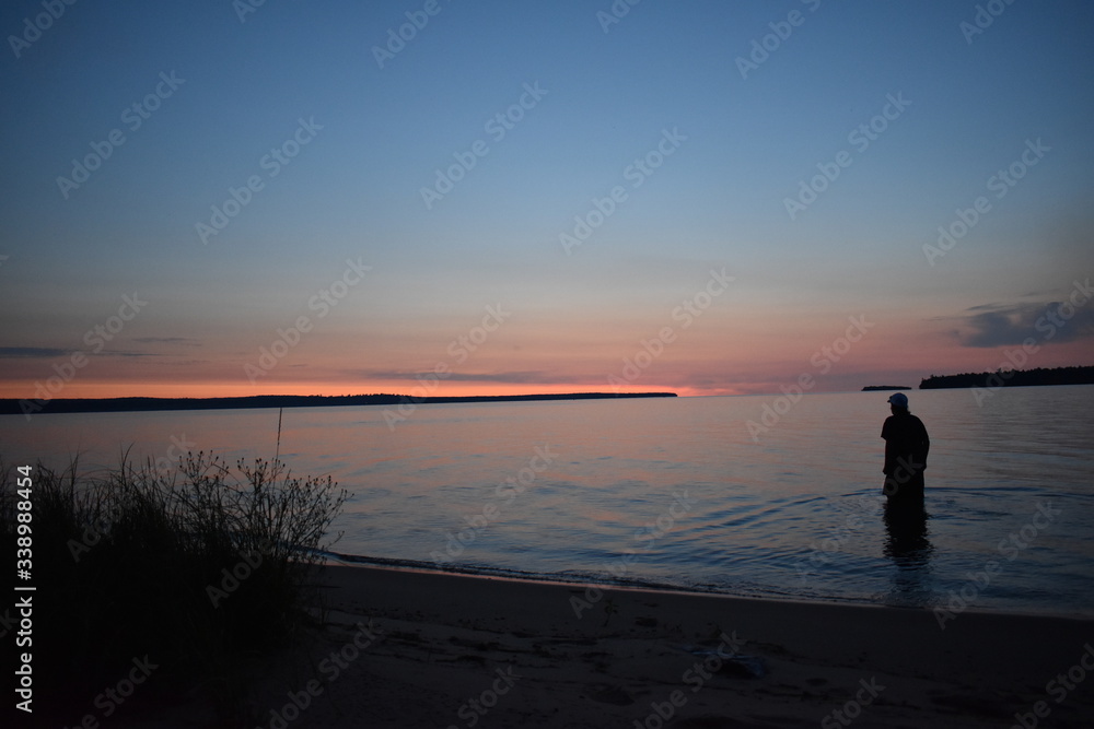 Silhouette person in lake at sunset Silhouette person in lake at sunset