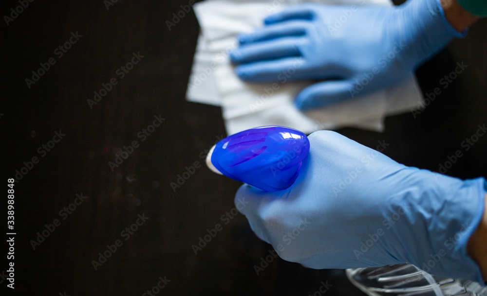 surface home cleaning spraying antibacterial sanitizing spray bottle disinfecting against COVID-19 spreading wearing medical blue gloves. Sanitize surfaces prevention in hospitals and public spaces. surface home cleaning spraying antibacterial sanitizing spray bottle disinfecting against COVID-19 spreading wearing medical blue gloves. Sanitize surfaces prevention in hospitals and public spaces.